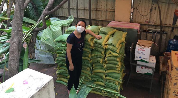 Claire devant des sacs de riz recoltés