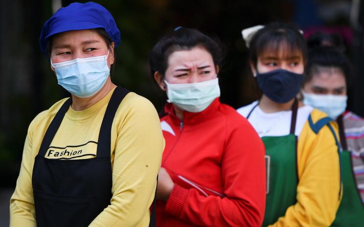 Des travailleuses masquees font la queue pour se faire tester au coronavirus en Thailande