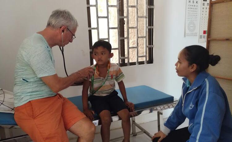 Jean Pierre LEBOIS auscultant un enfant de l'ecole du Bayon