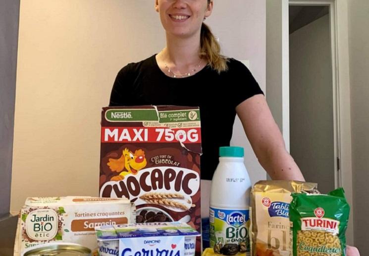 Une étudiante pose avec son panier alimentaire 