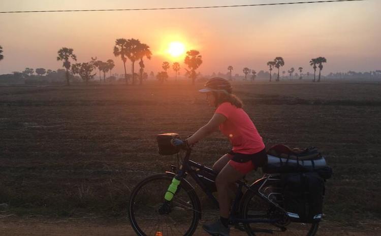 Clotilde sur son vélo au coucher du soleil au Cambodge