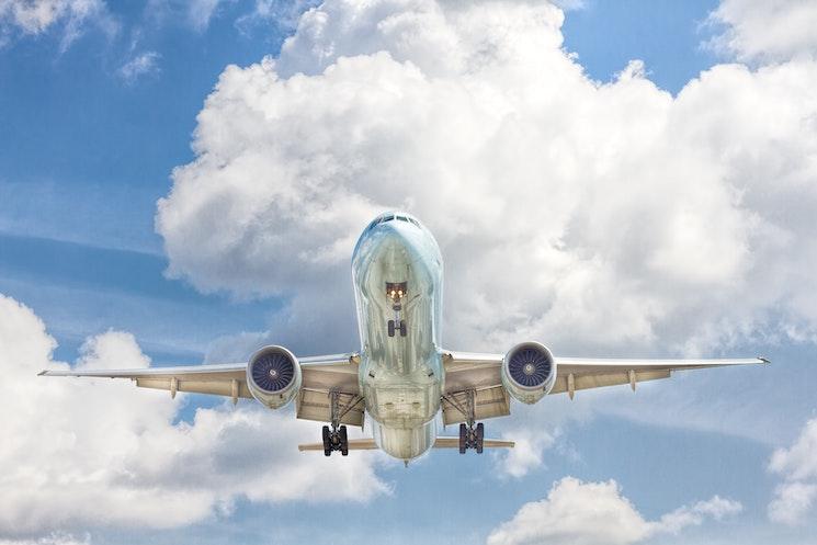 Un avion dans le ciel avec des nuages et du ciel bleu 