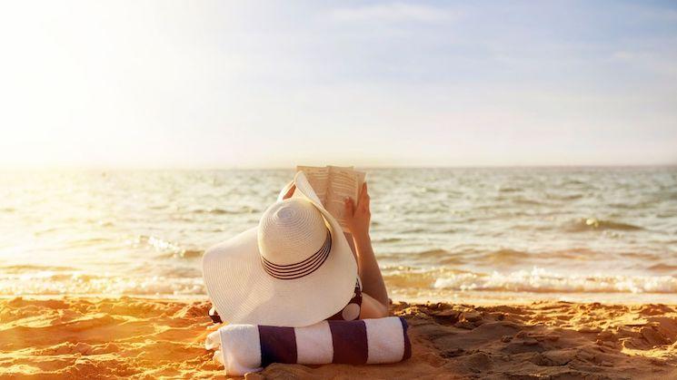 Une femme lit sur la plage en vacances