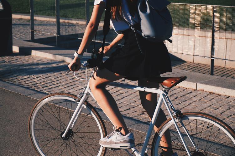 Une femme en jupe à vélo.