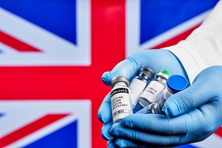 Union Jack et mains portant des doses de vaccin