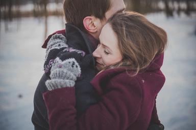 Deux amoureux s'enlaçant au beau milieu de la neige