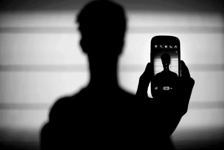 Une silhouette tenant un téléphone