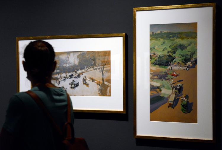 Une femme en train de regarder des tableaux dans un musée