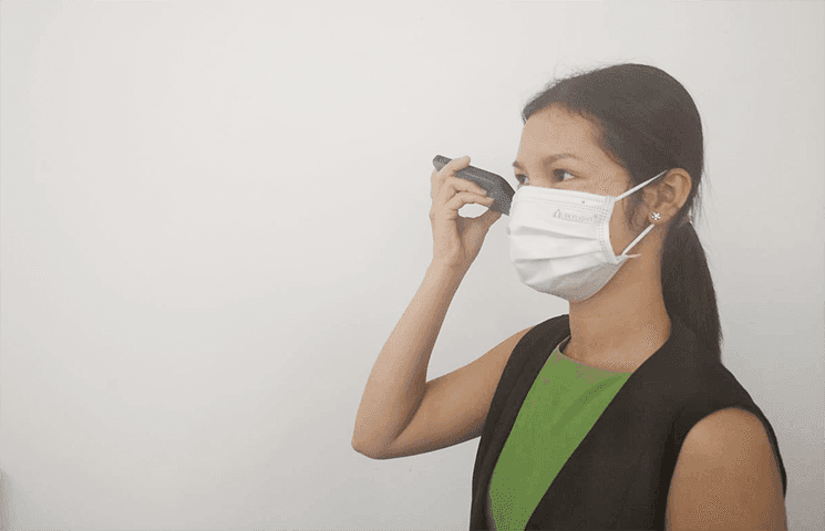 Cambodgienne avec masque ecoutant un message vocal 2