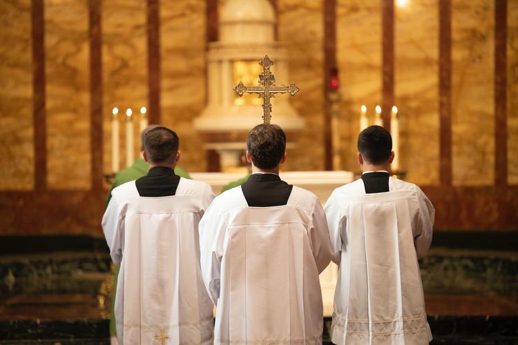 Des prêtres de dos dans une église