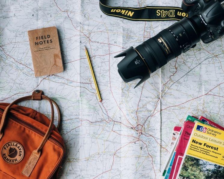 Appareil photo, sac et carte du monde posés sur une table