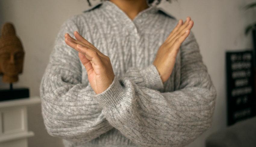 Une personne qui croise les bras en signe de refus