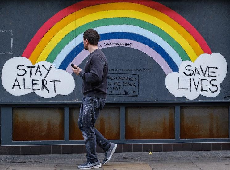 Covid Omicron un jeune homme à Londres devant un arc en ciel