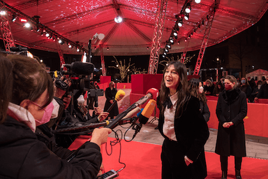 Charlotte Gainsbourg répondant à une interview sous un chapiteau rouge