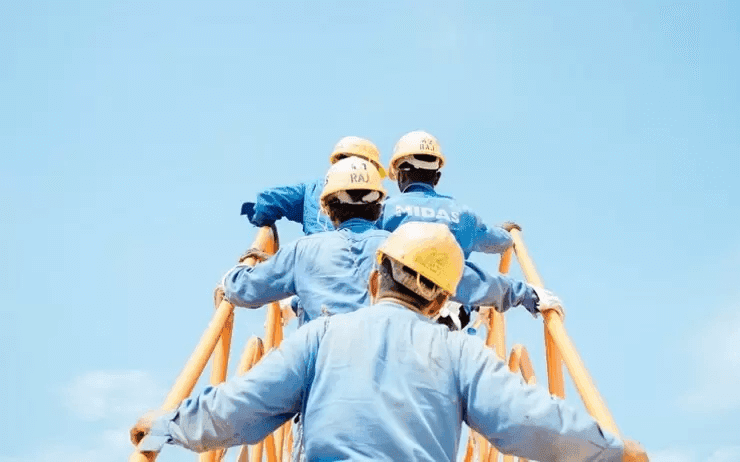 des hommes en chemise et casque jaune montent une échelle