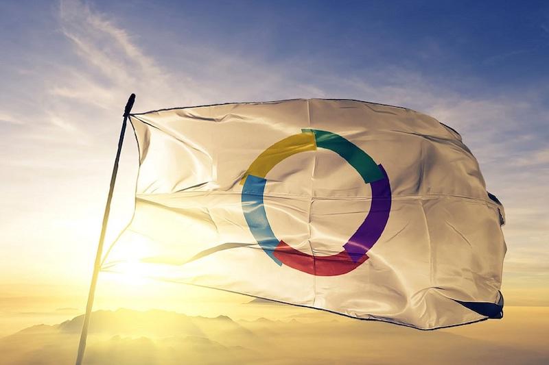 un drapeau blanc avec un cercle de couleurs au centre