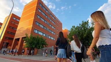 des femmes en train de marcher vers un bâtiment orange