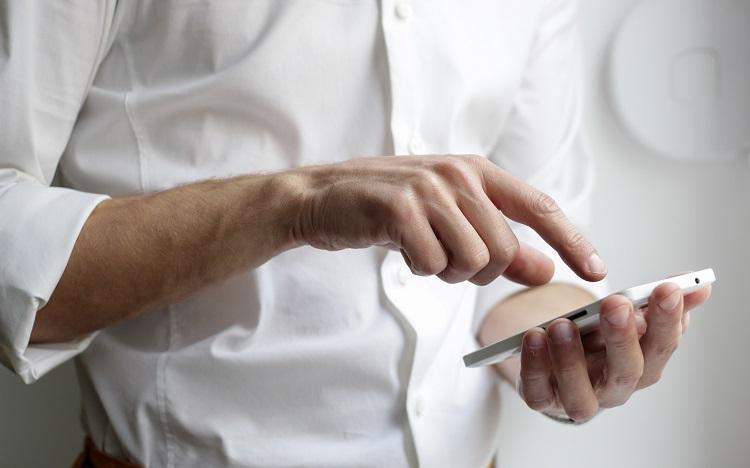 homme en chemise blanche avec téléphone portable