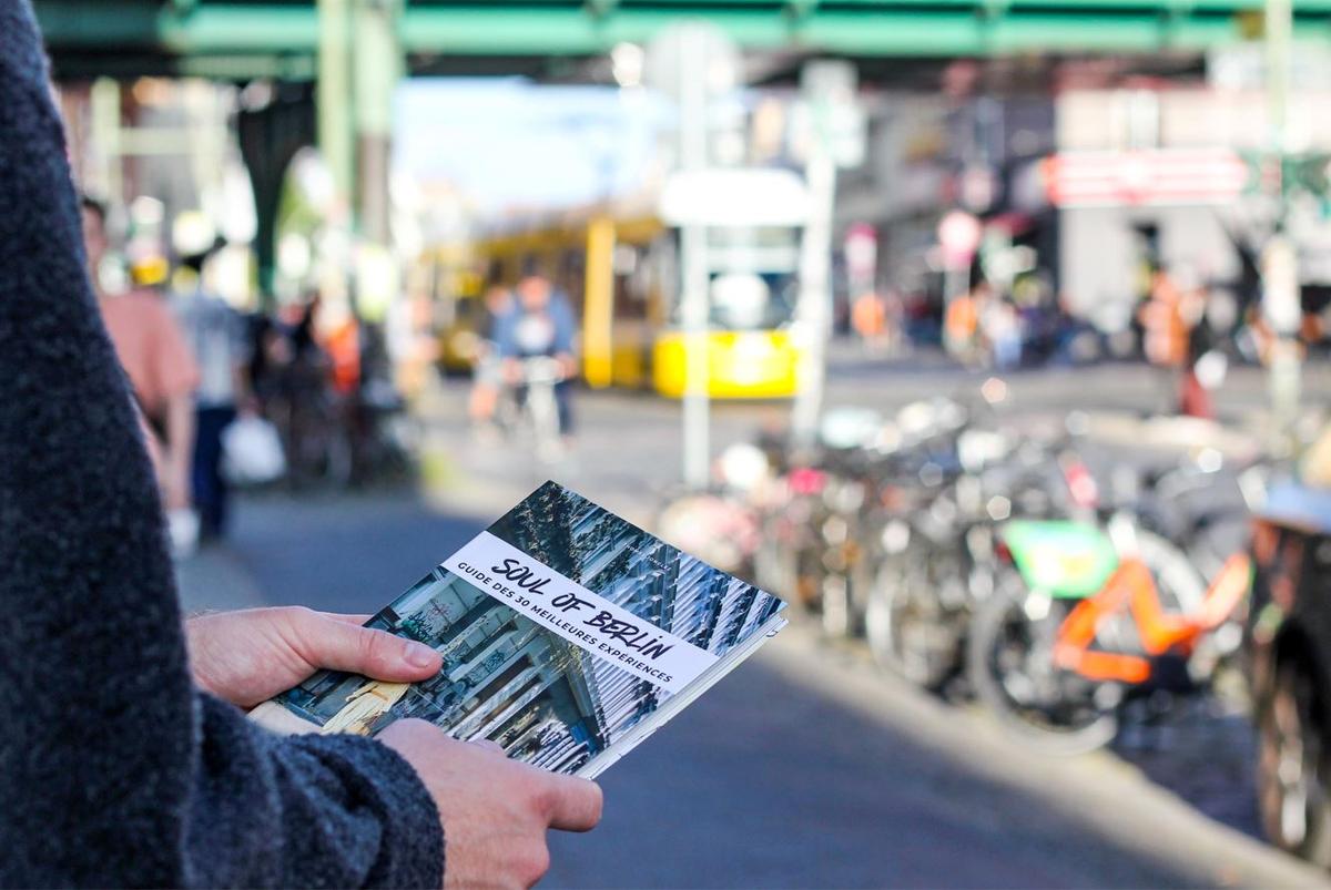 Une jeune lit le guide Soul of Berlin dans la rue 