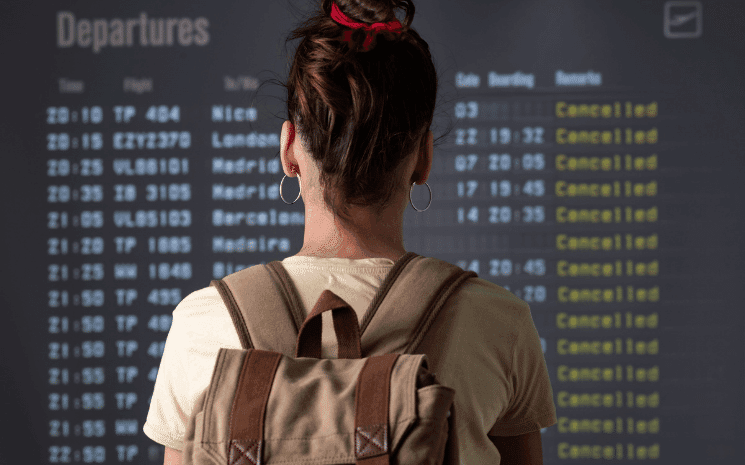 Une voyageuse à l'aéroport devant des vols retardés et annulés