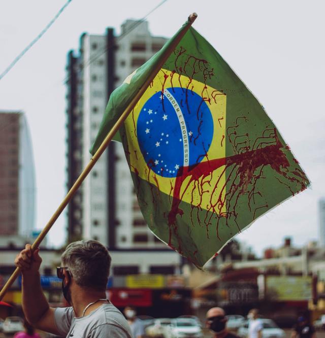 Un manifestant brandit un drapeau du Brésil avec su sang dans les rues de Rio 