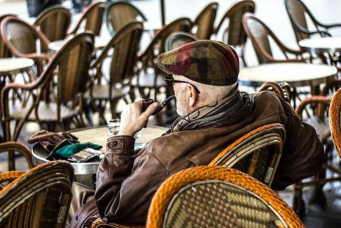 un homme fume en terrasse 