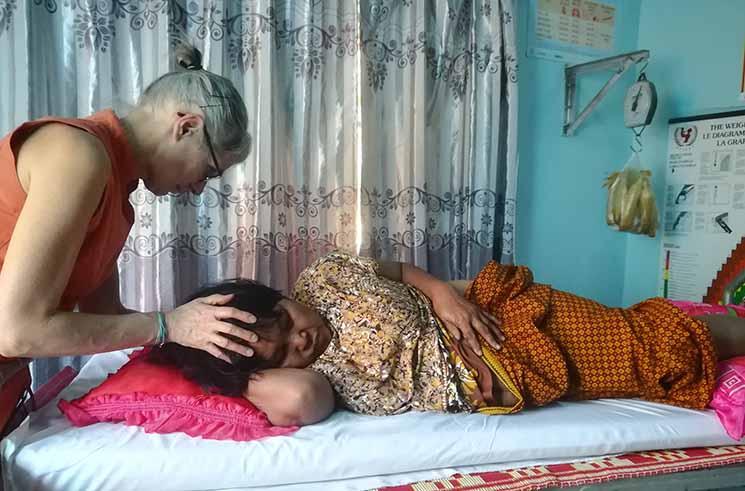 Un homme cambodgien pose ses mains sur un patient pour apaiser ses douleurs 