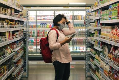 un femme avec un masque dans un rayon de supermarché à Valencia