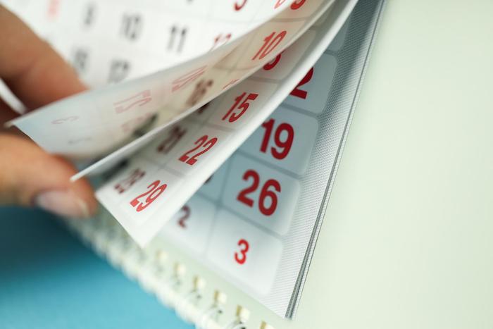 une main en train de feuilleter un calendrier