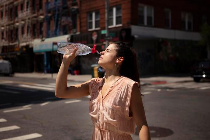 Une femme s'asperge d'eau pour combattre la chaleur