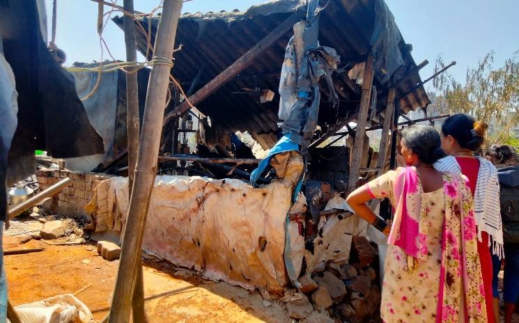 Deux femmes regardant les restes de leur maison après l'incendie à jamrushi nagar