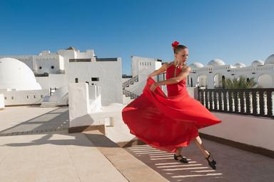 Une danseuse de flamenco vétue d'une robe rouge en train de danser