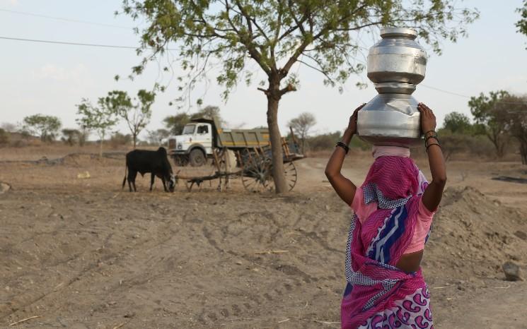 Une femme portant des pots d'eau au Rajasthan en Inde