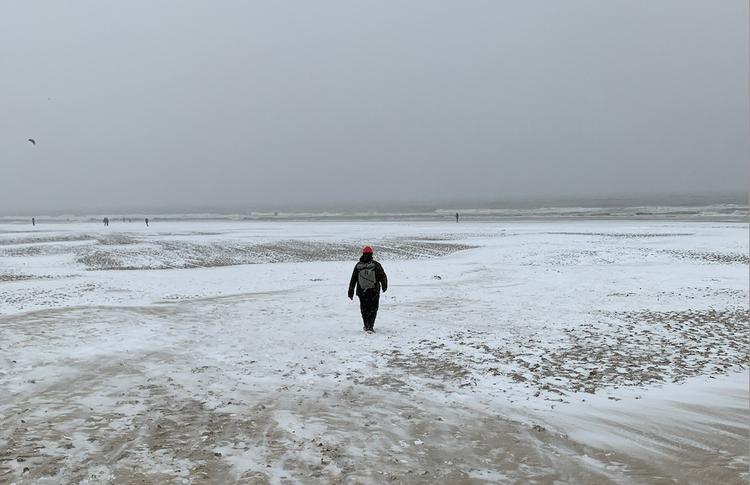 Aaron Boles marchant sur la plage de Scheveningen enneigée (Photo: Emma Dailey)