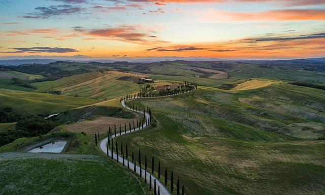 une route sinueuse traverse les collines en Toscane