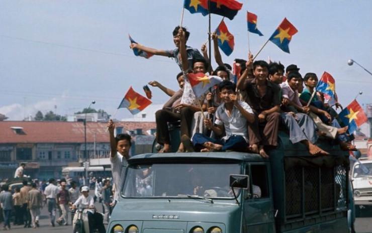 Des Vietnamiens brandissent le drapeau du Front national de libération du Sud-Vietnam