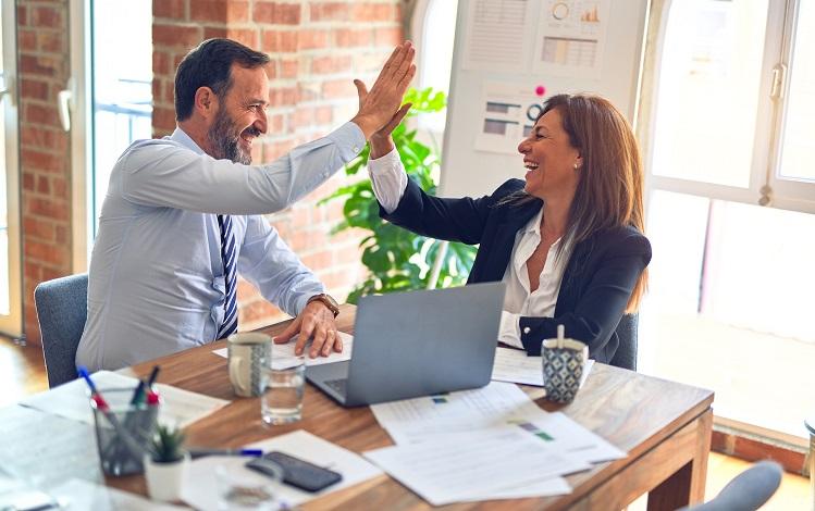 un homme et une femme se tape dans la main au travail