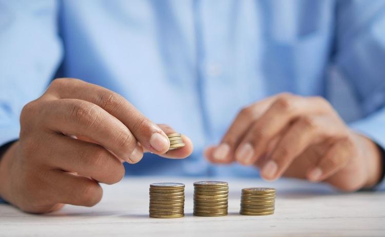 un homme fait des piles avec des pièces de monnaie