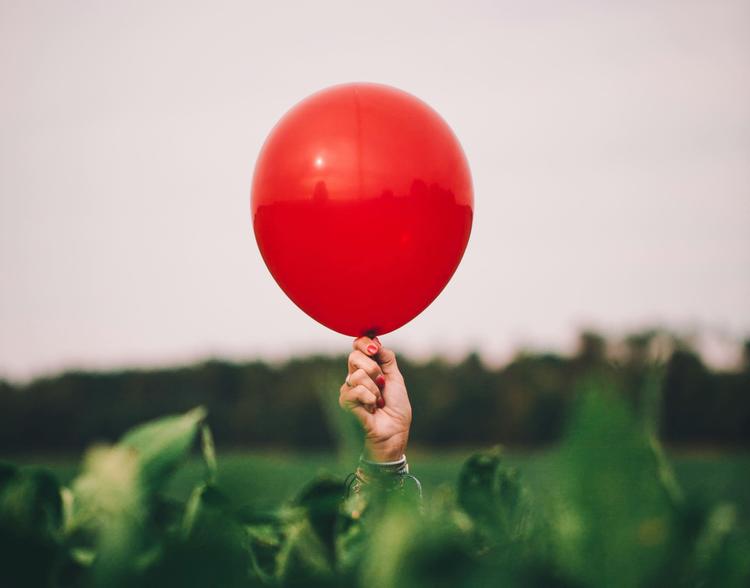 Un ballon rouge dans un champ.