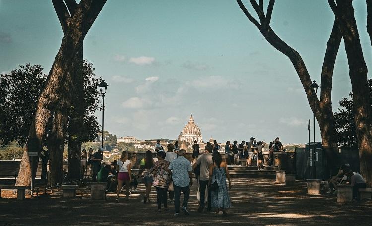 des gens marchent devant un monument de rome