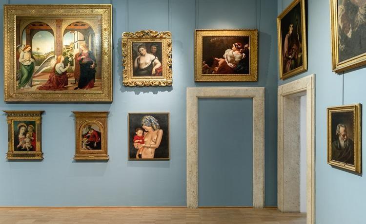 tableaux exposés sur un mur au fond bleu