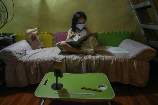 Jeune philippine étudie sur son lit